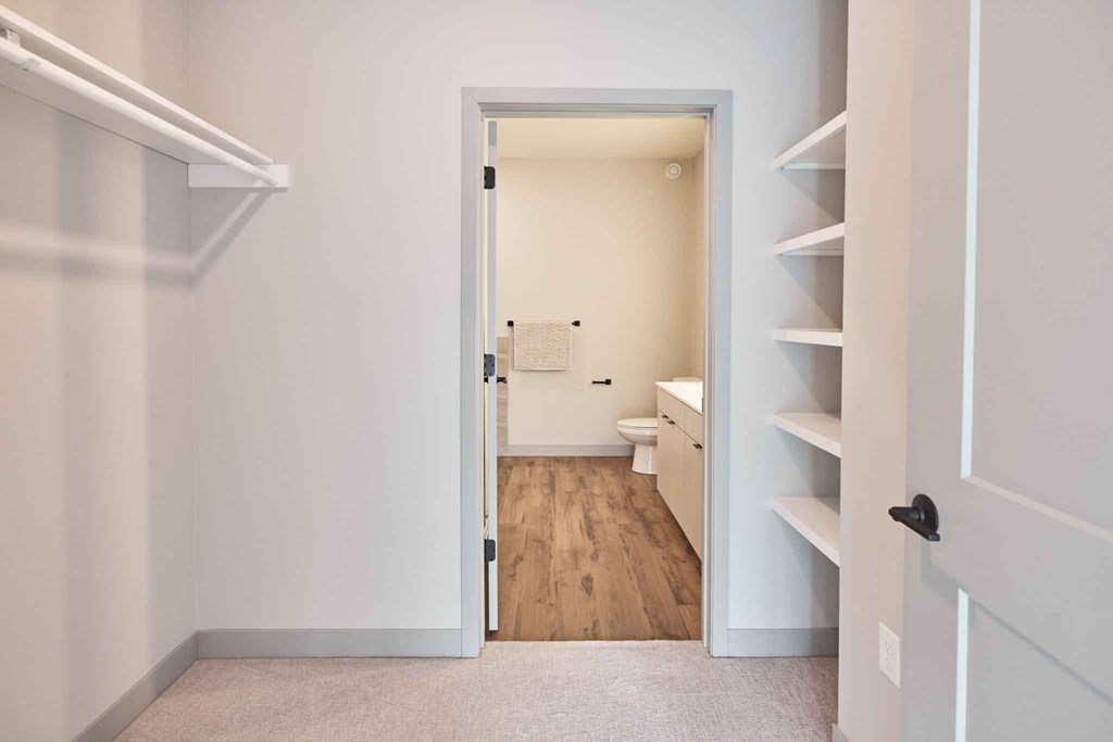 a bedroom with a closet and a door open to a bathroom