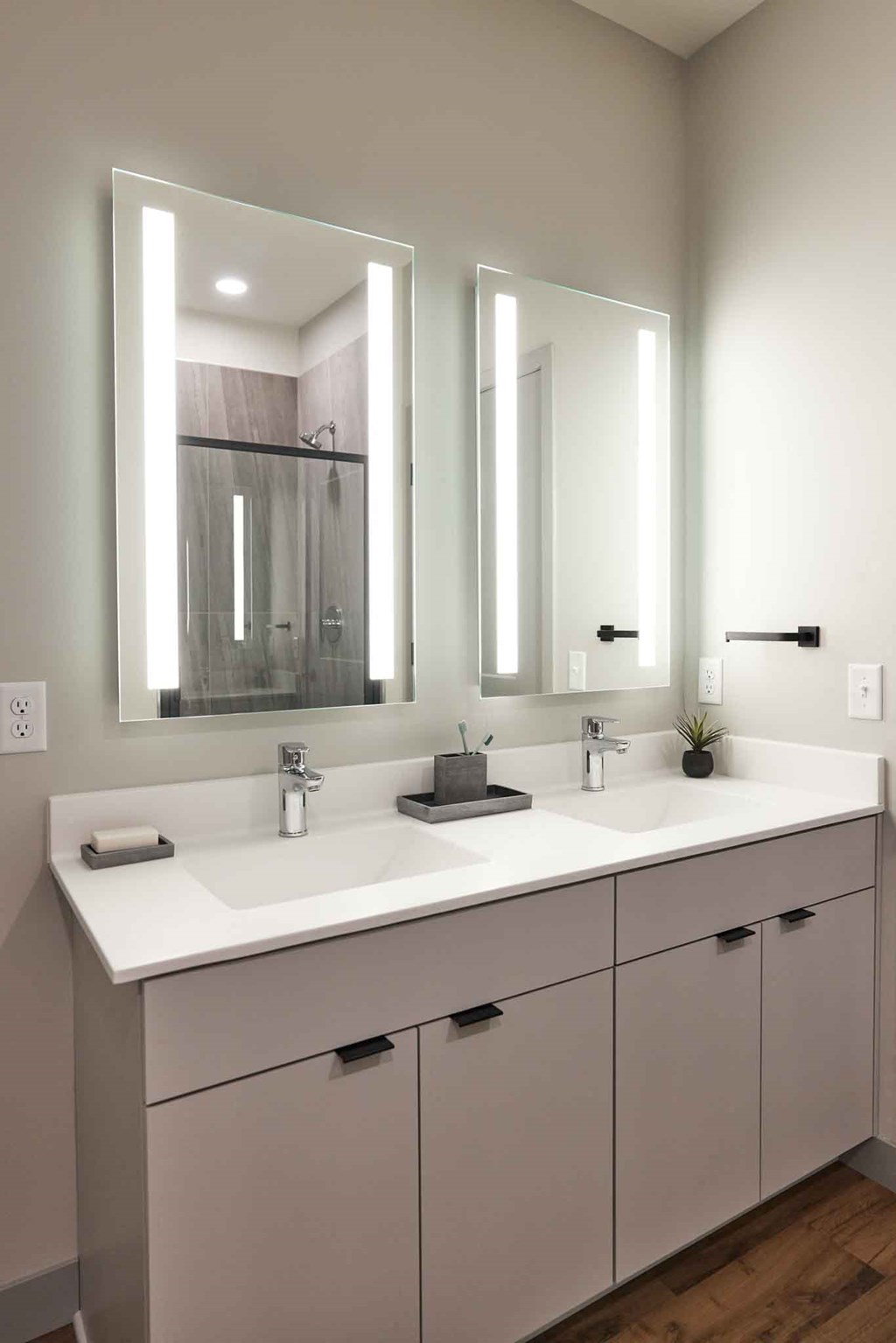 a bathroom with two sinks and three mirrors