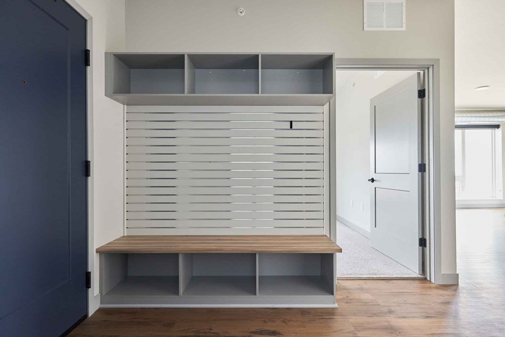 a small closet with white shutters in a room with a door