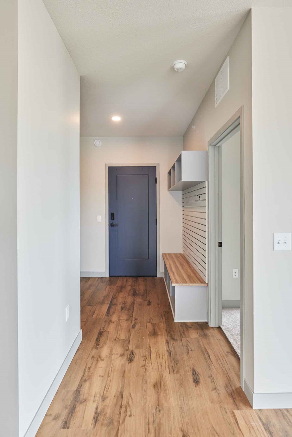 a room with a door and a hallway with a wooden floor