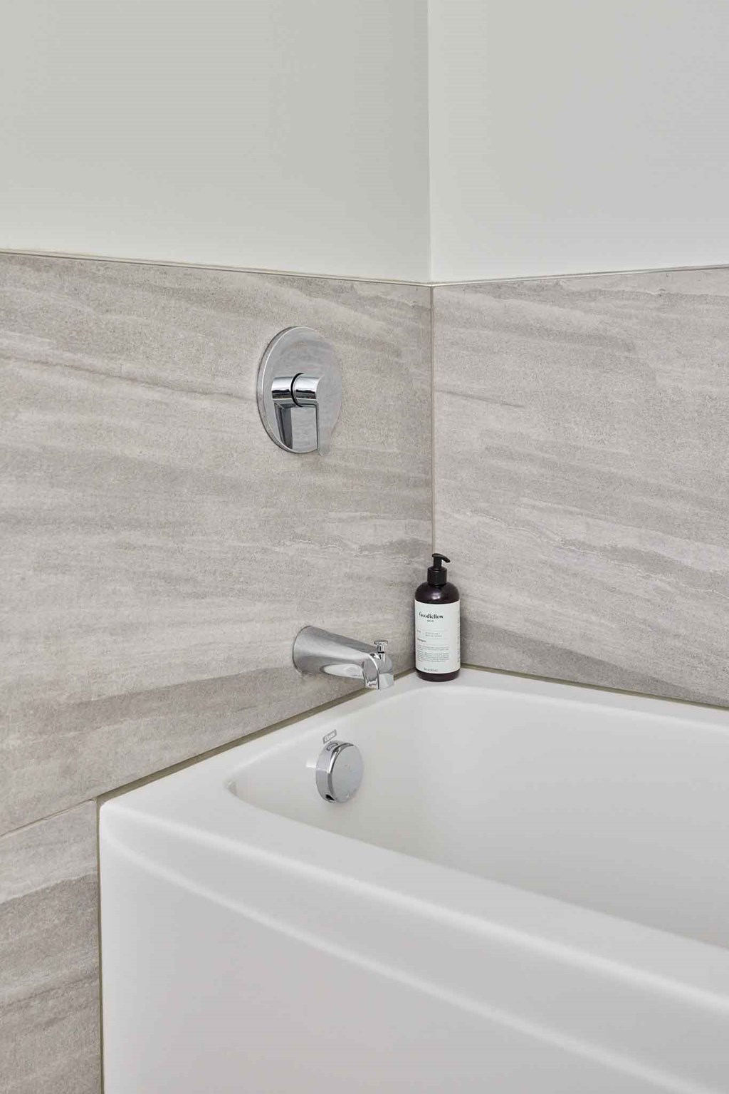 a bathroom with a bath tub and a soap dispenser