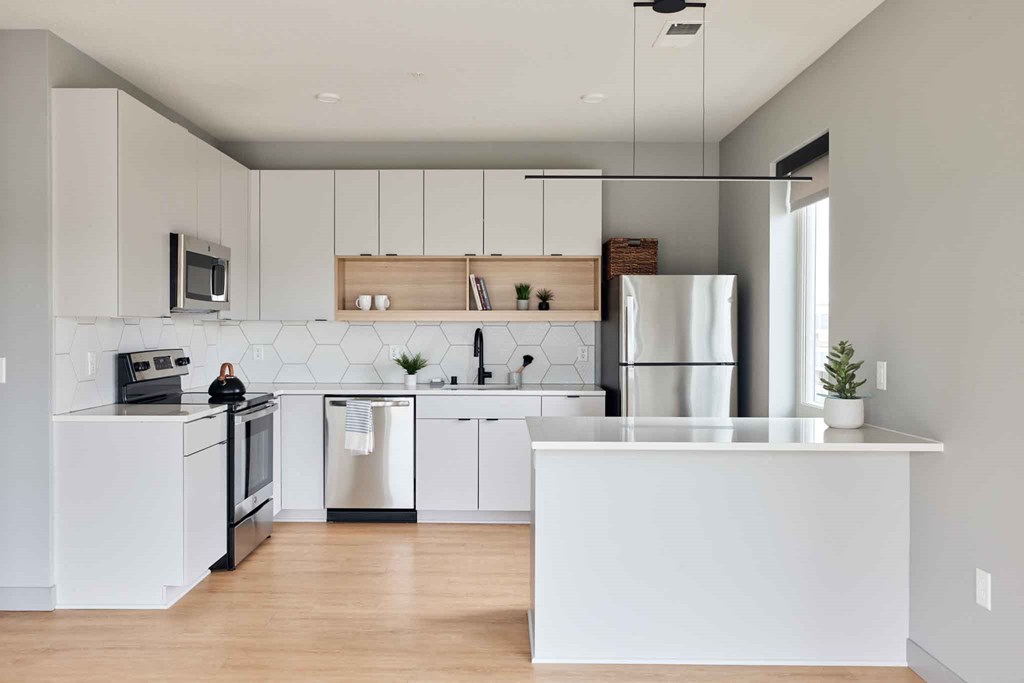 a white kitchen with a counter top and a refrigerator