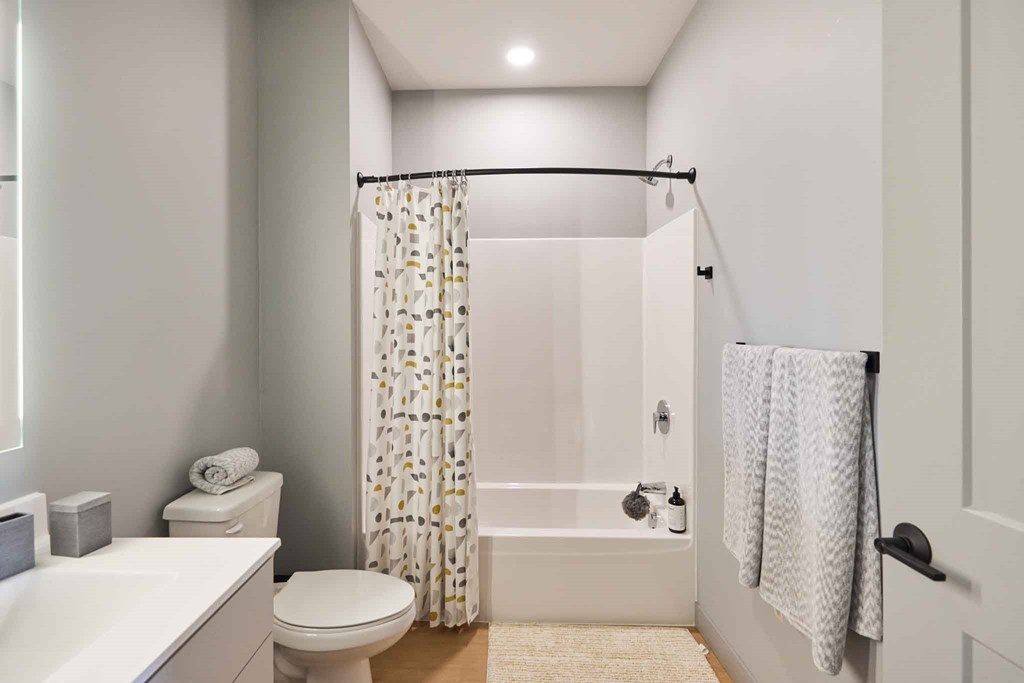 a bathroom with a shower and a toilet and a sink