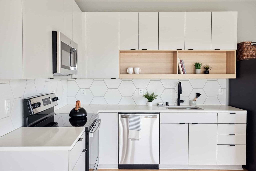 a kitchen with white cabinets and a stove and a sink