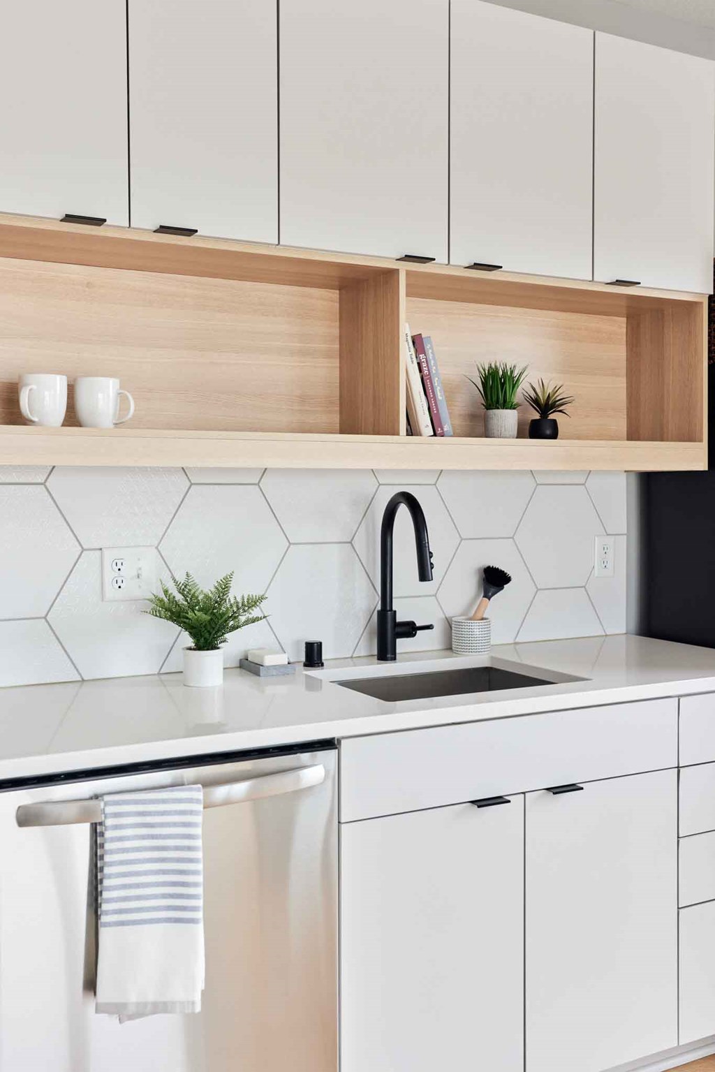 a kitchen with white cabinets and a sink and a black faucet