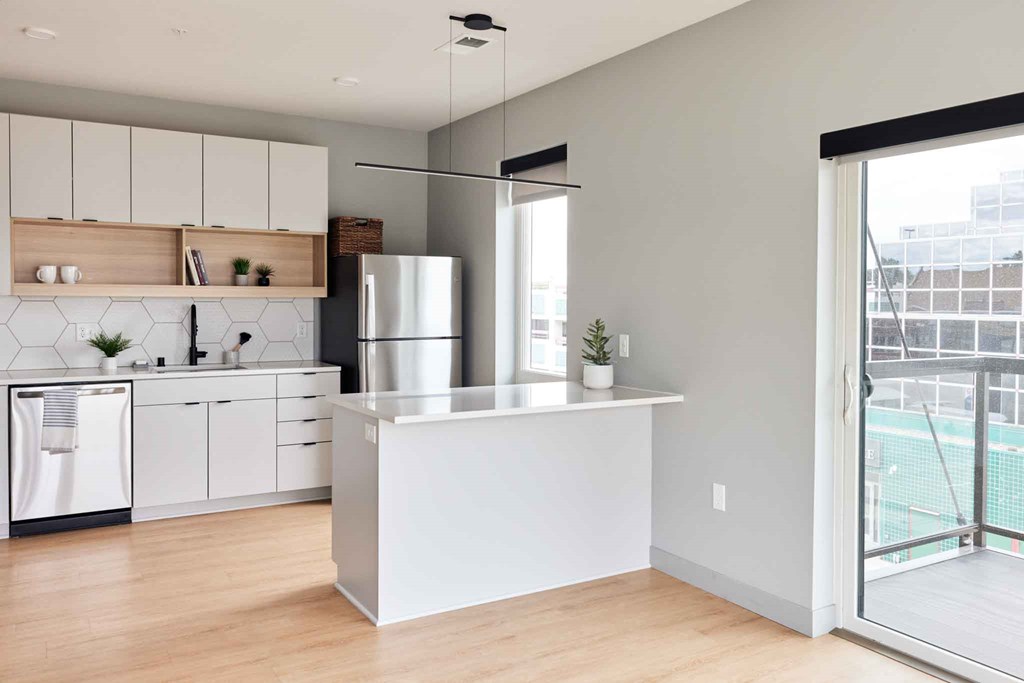 a white kitchen with a large window and a door