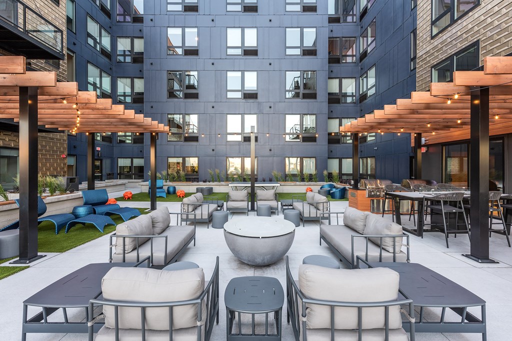 an open courtyard with tables and chairs in front of a building