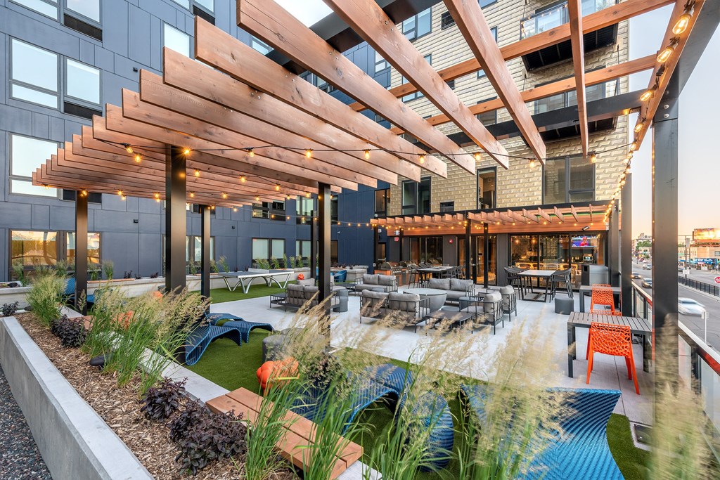 a patio with tables and chairs and a building in the background