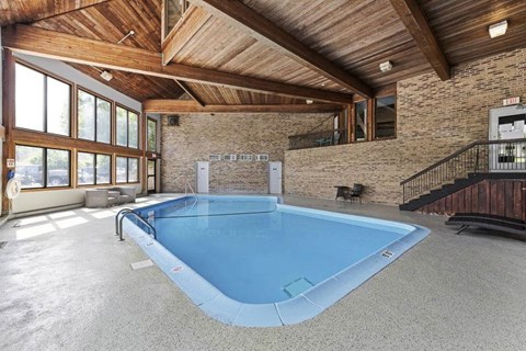 A large indoor swimming pool is the centerpiece of this spacious room.