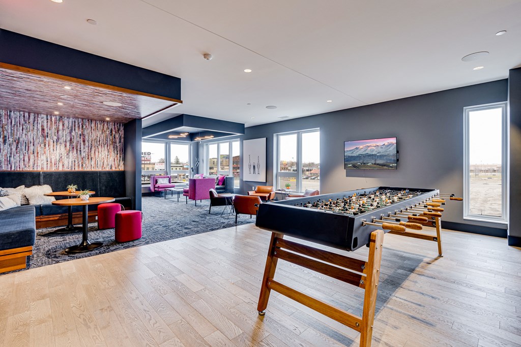 a game room with a bar and a seating area with tables and chairs