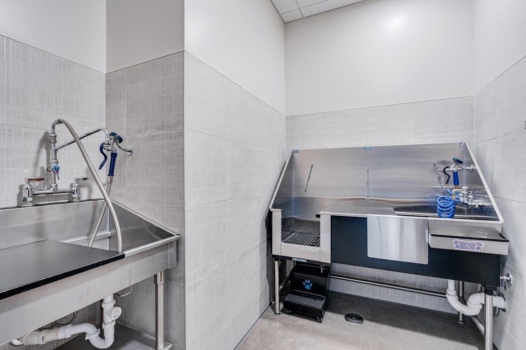 a large stainless steel kitchen with a sink and a workstation