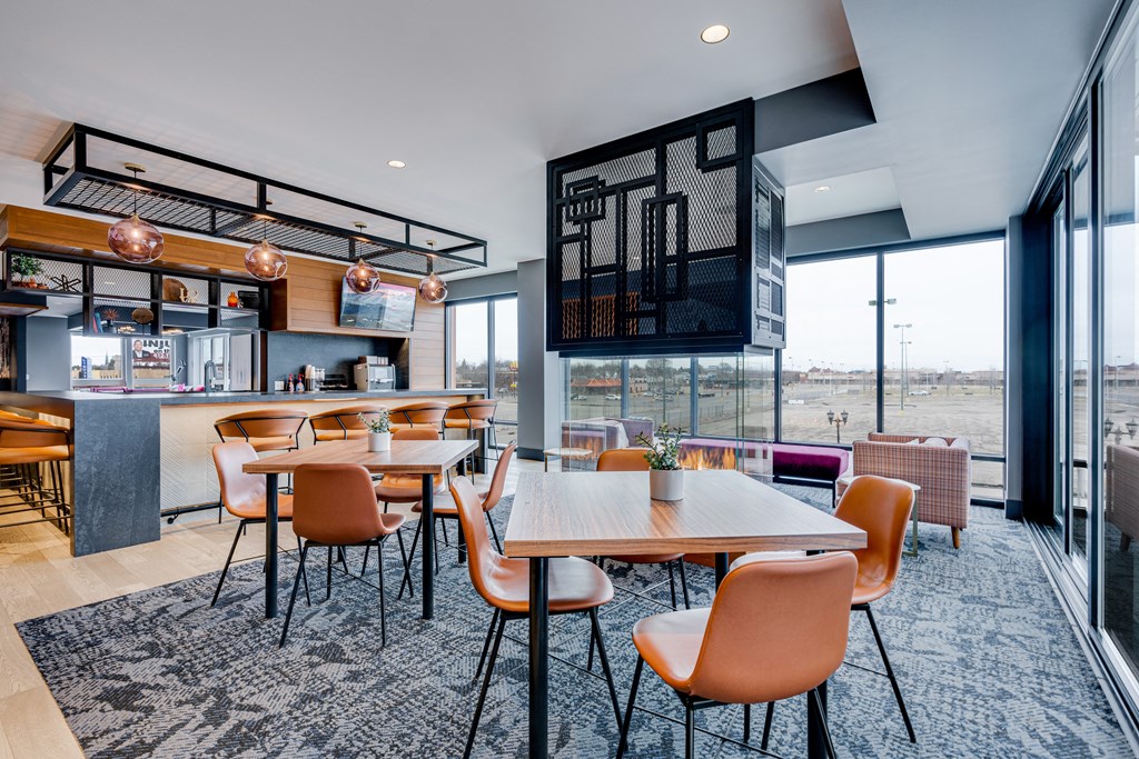 a dining area with tables and chairs and a bar