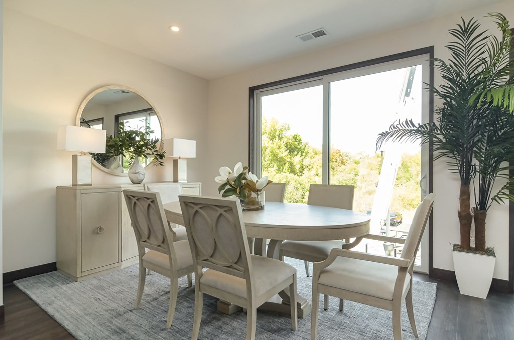 a dining room with a table and chairs and a large window
