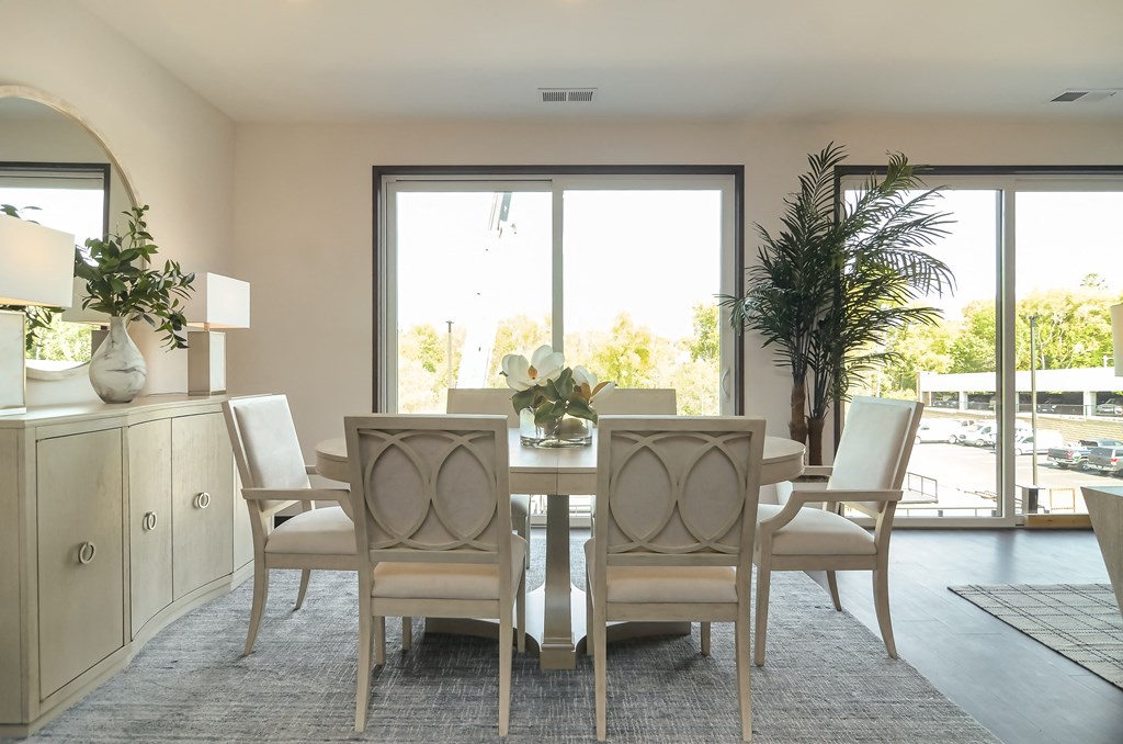 a dining room with a table and chairs and a large window