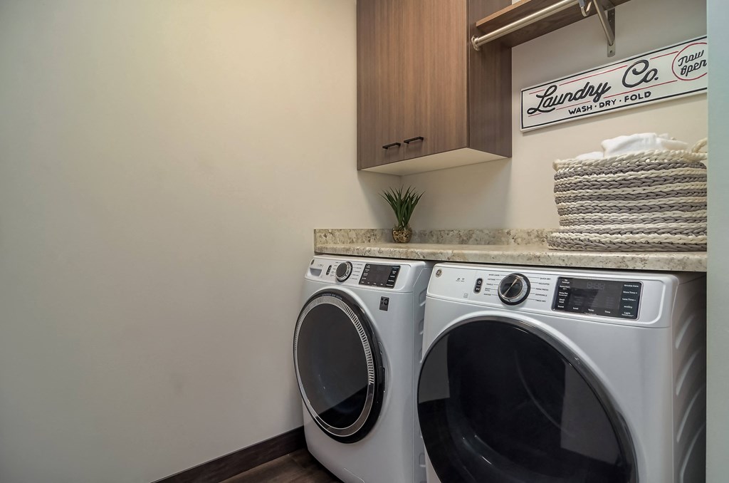 a washer and dryer in a laundry room with a cabinet and a sink
