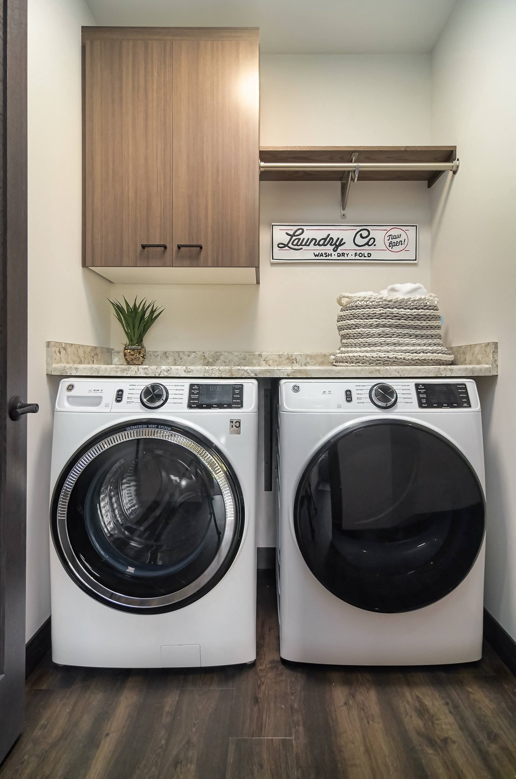 a washer and dryer in a laundry room with a counter and a sink