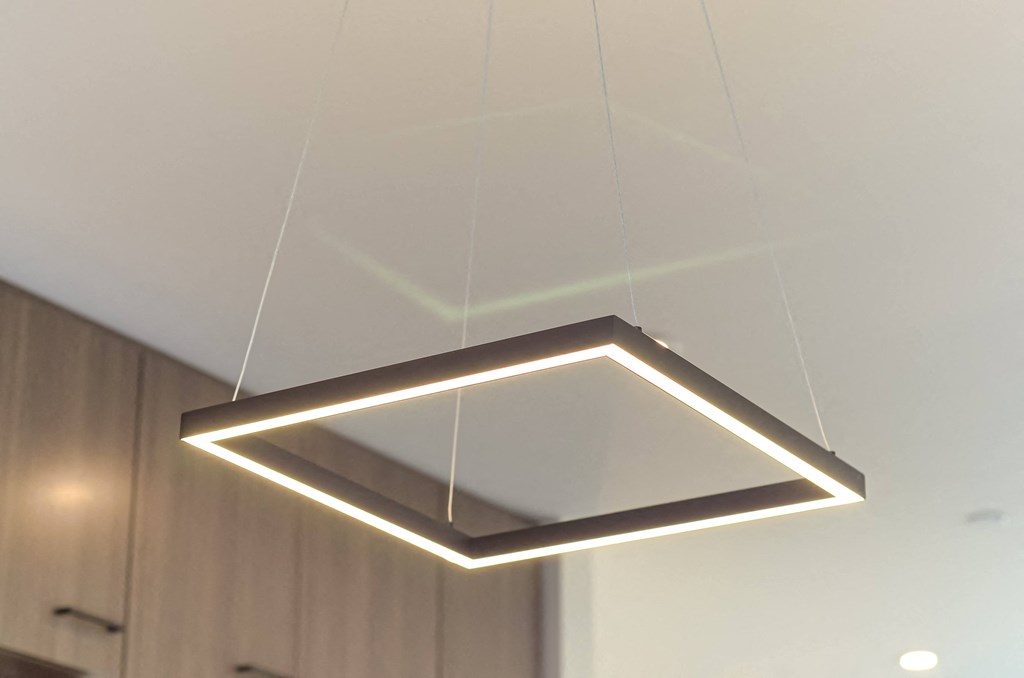 a triangular lighting fixture hanging from a ceiling