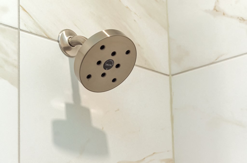 a close up of a shower head in a bathroom