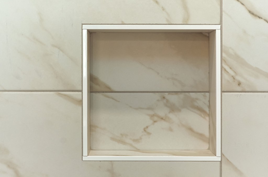 a white marble wall with a mirror on it