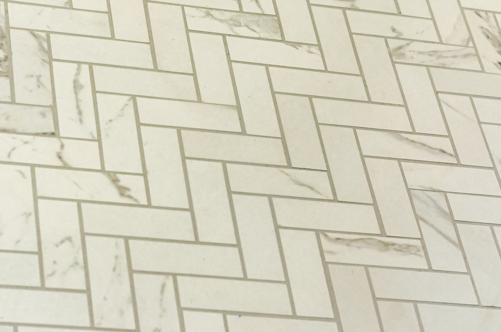 a tile floor with a diagonal pattern in white and gray