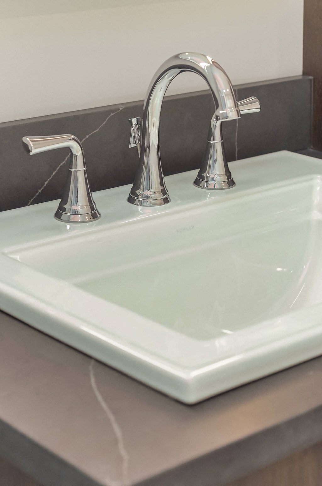 a close up of a bathroom sink with two faucets