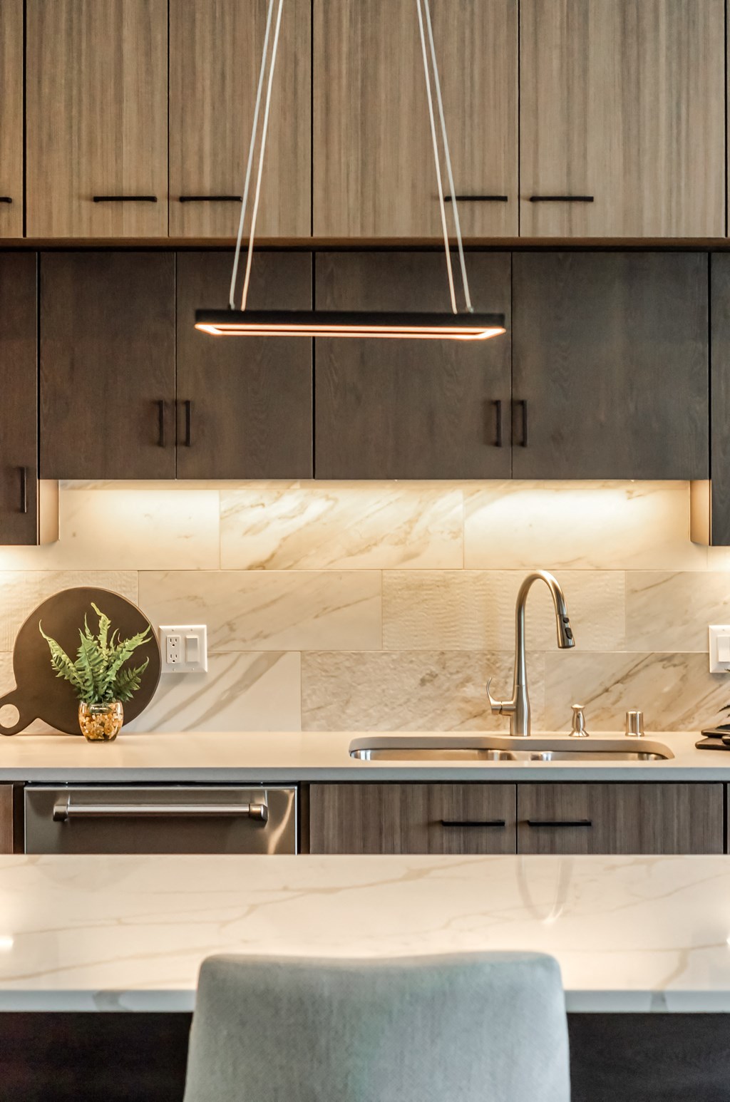 a kitchen with wood cabinets and marble counter tops and a sink