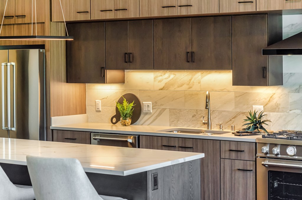 a kitchen with wooden cabinets and a marble counter top
