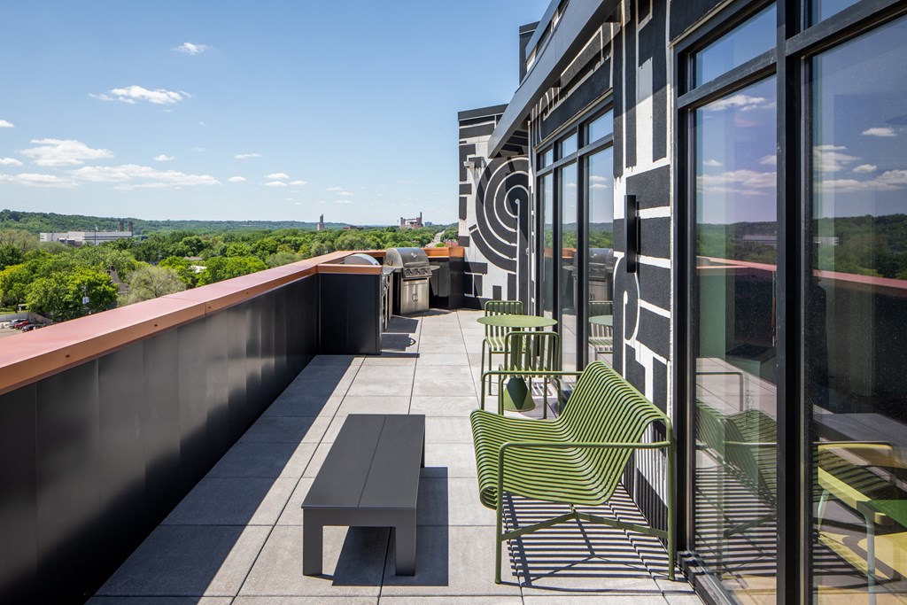 a balcony with chairs and a table overlooking a city