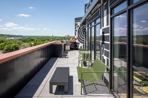a balcony with chairs and a table overlooking a city