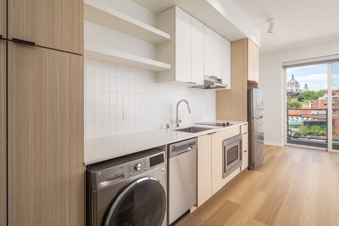 a kitchen with a washing machine and a sink and a window