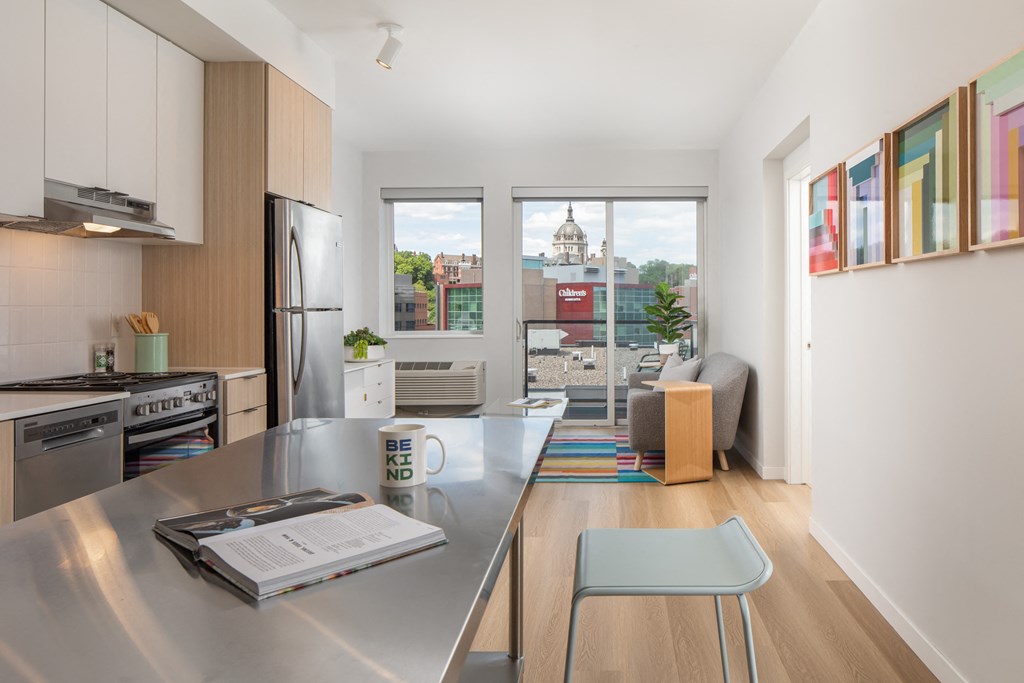 a kitchen and living room with a stainless steel counter top and a large window
