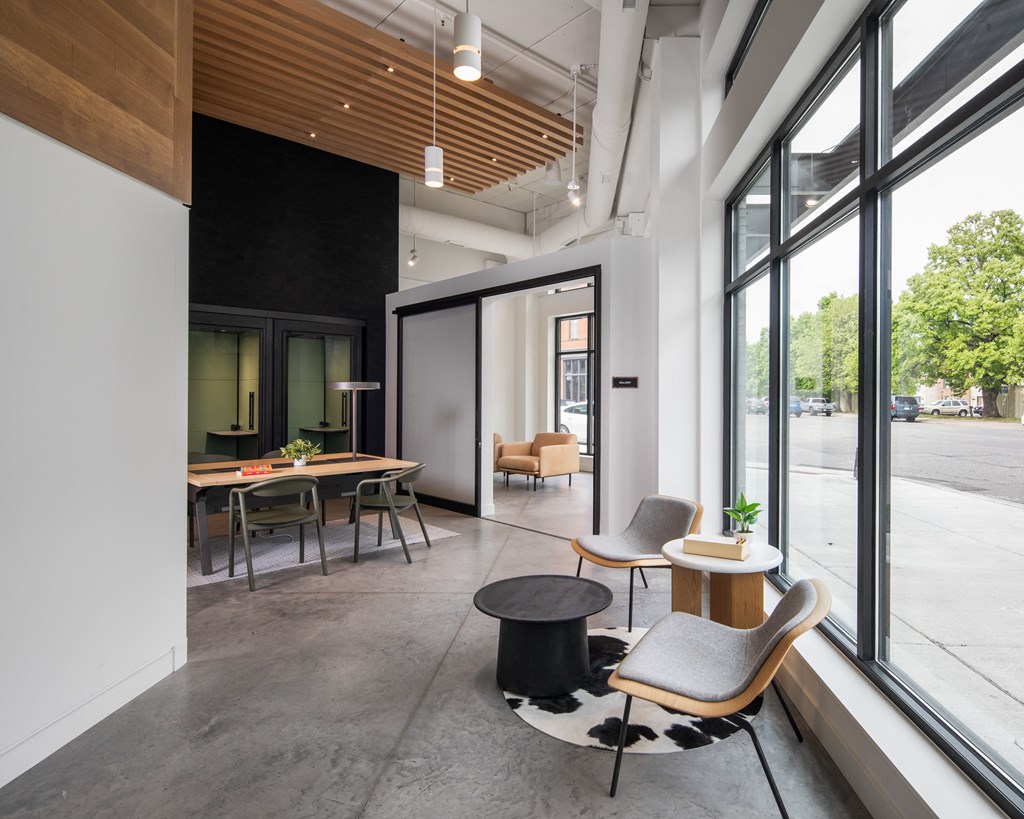 a lobby with chairs and tables and large windows