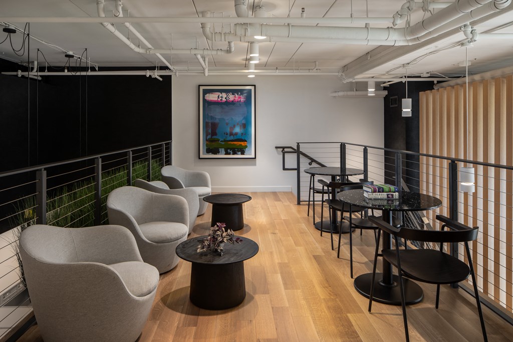 a room filled with chairs and tables and a painting on the wall