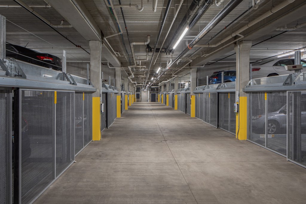 the inside of a parking garage with cars in cages