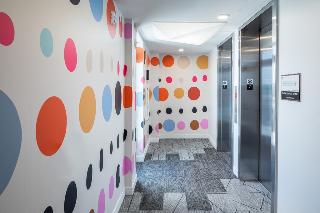 a hallway with colourful dots on the wall and a door