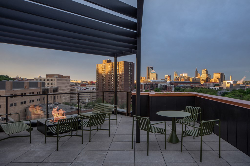 a terrace with tables and chairs and a view of the city