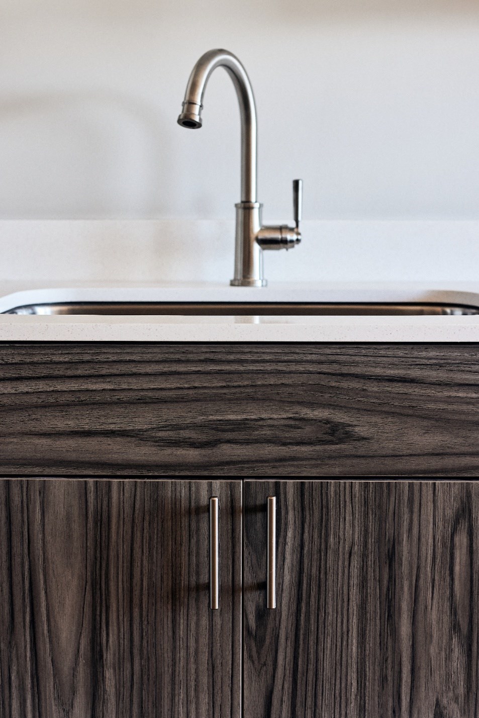 a kitchen with wooden cabinets and a sink and a tap