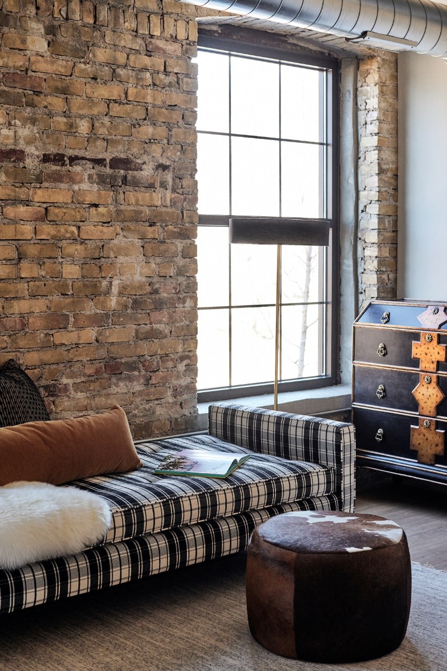 a living room with a couch and a brick wall