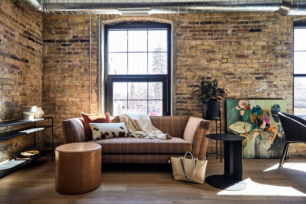 a living room with a couch and a brick wall