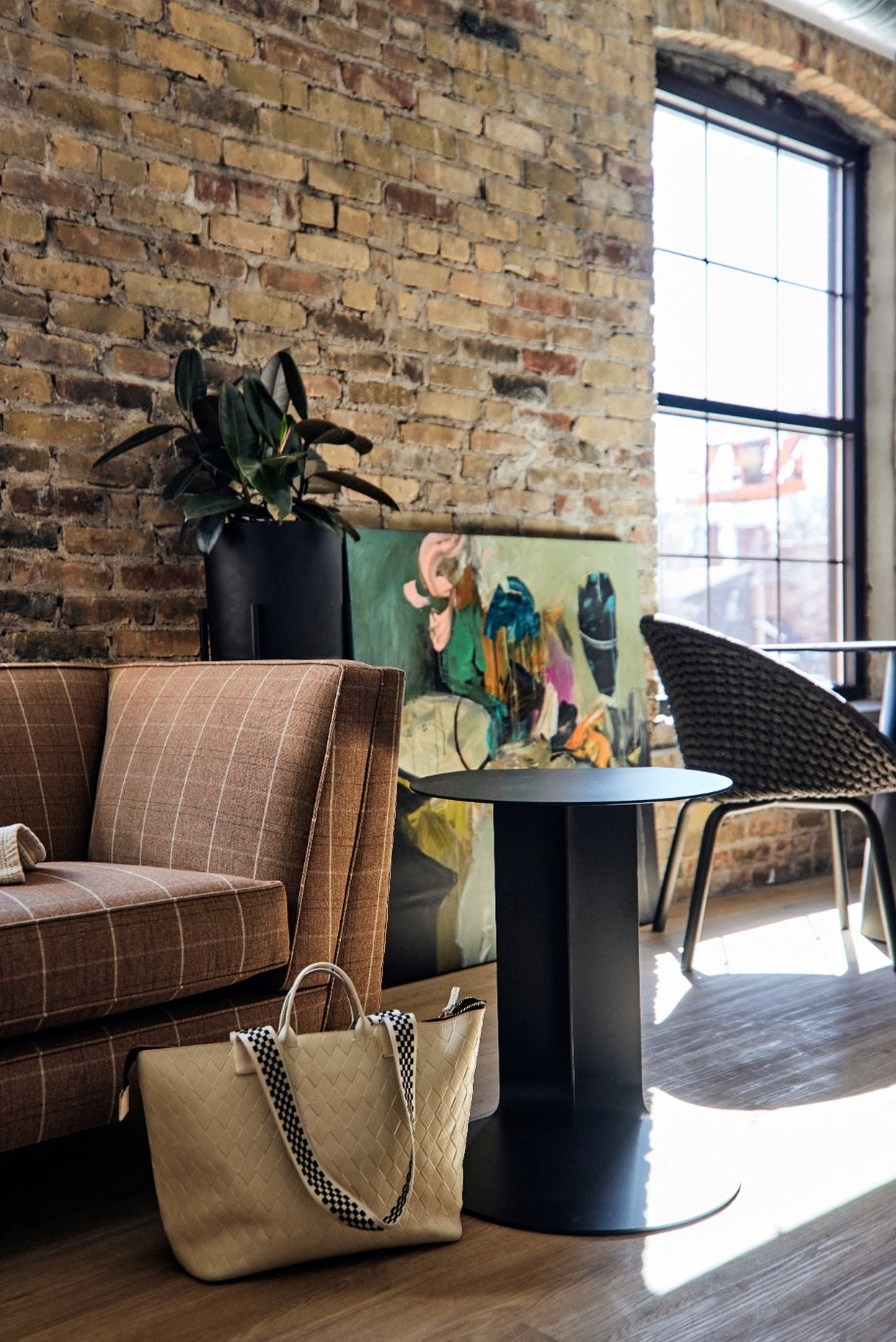 a living room with a couch and a table and an exposed brick wall