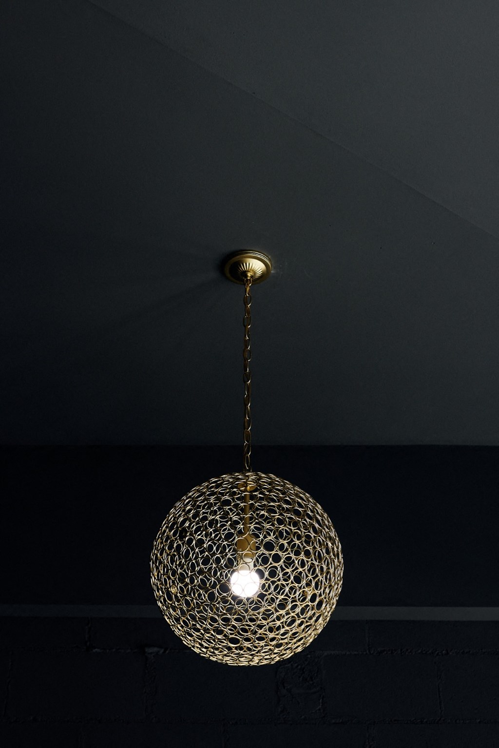 a chandelier with a light on it in a dark room