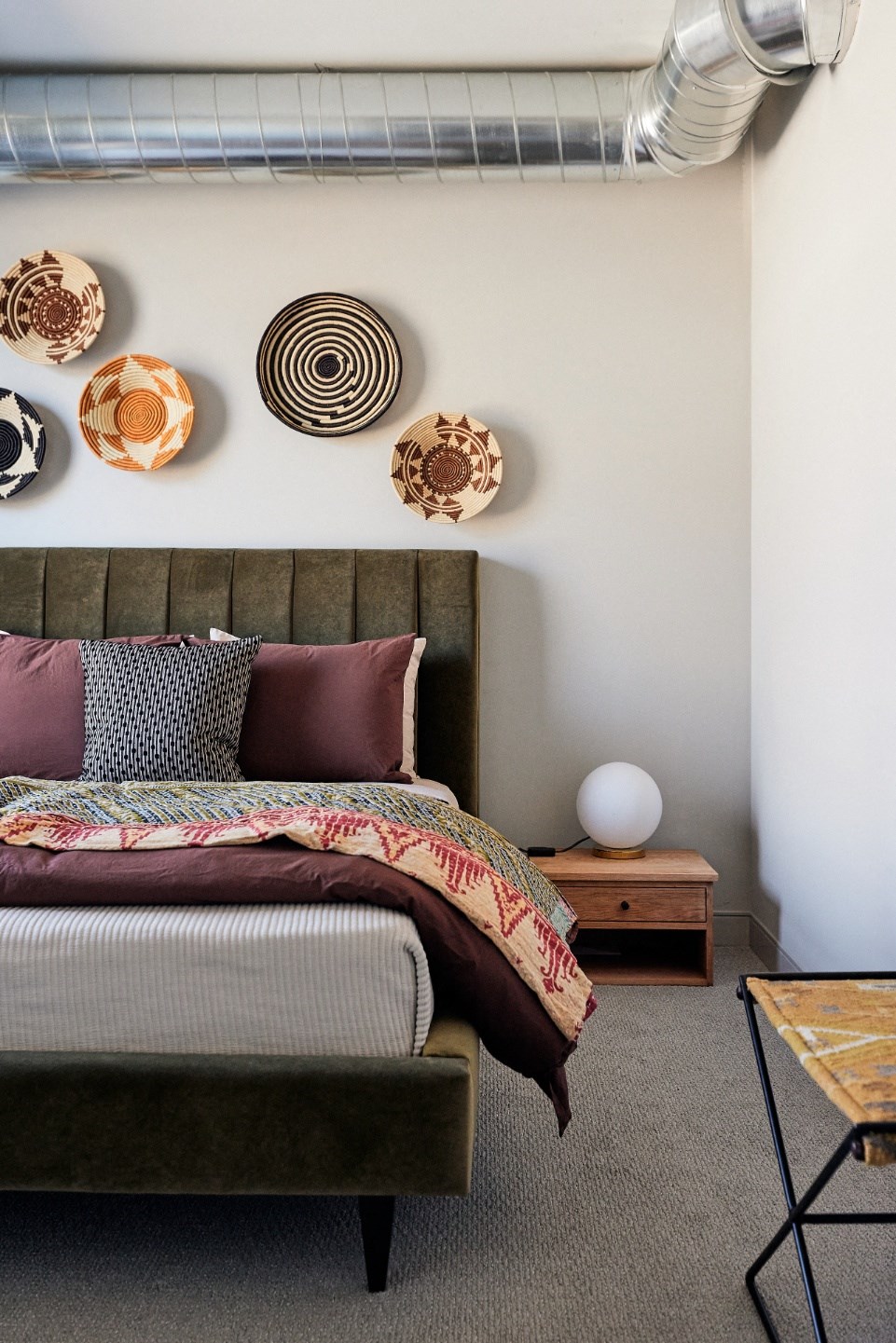 a bedroom with a bed and several pieces of wall art on the wall above it