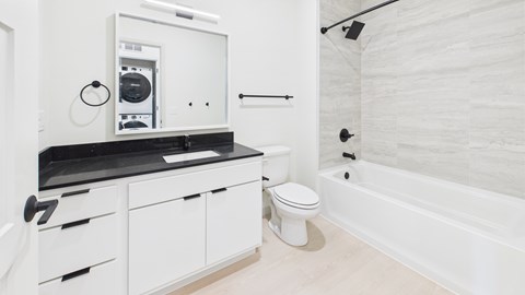 A white bathroom with a toilet, sink, and bathtub.