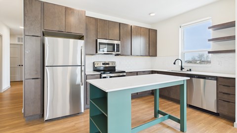 A kitchen with a stainless steel refrigerator and a white countertop.