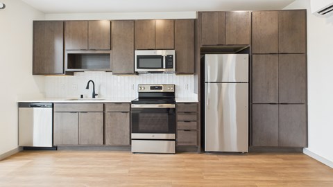 A modern kitchen with wooden cabinets and stainless steel appliances.