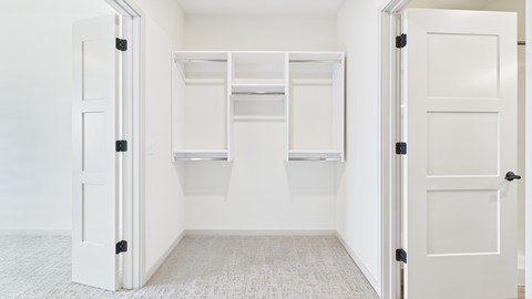 A white closet with two doors and shelves.