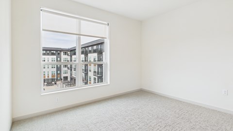 A white room with a large window overlooking a building.