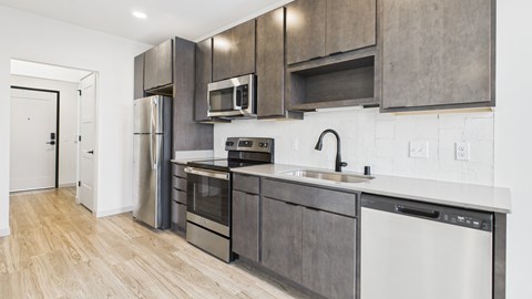 A modern kitchen with stainless steel appliances and wooden cabinets.