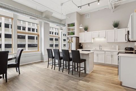 A kitchen with white cabinets and a wooden floor.