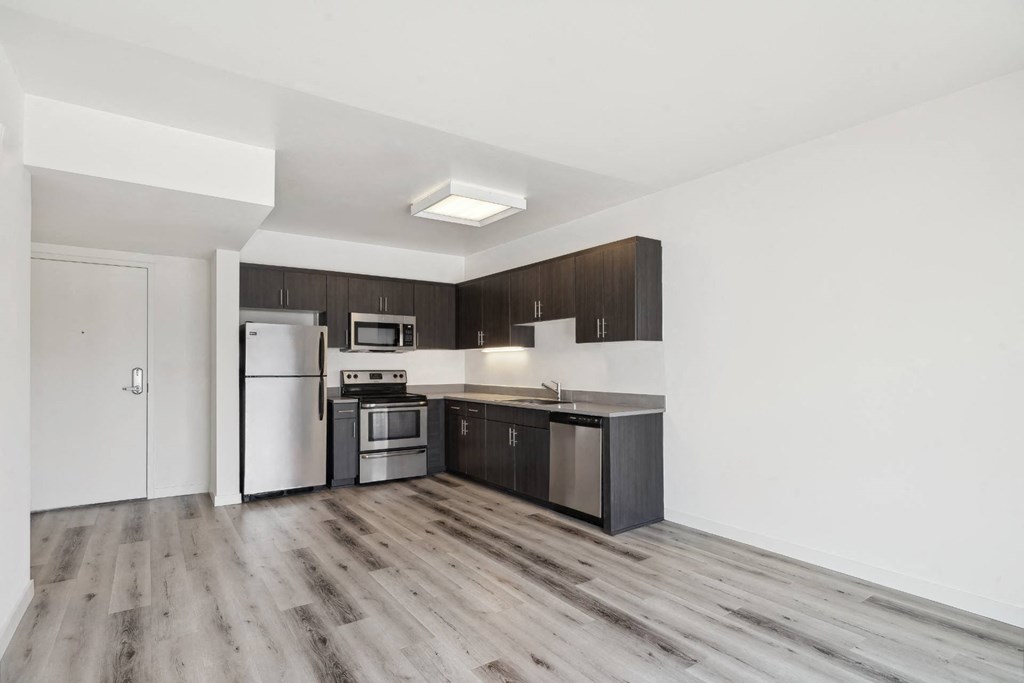spacious apartment with custom cabinets and stainless steel appliances in the kitchen at One Santa Fe apartments